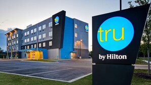 A hotel with a modern design, featuring a prominent 'tru by Hilton' sign.