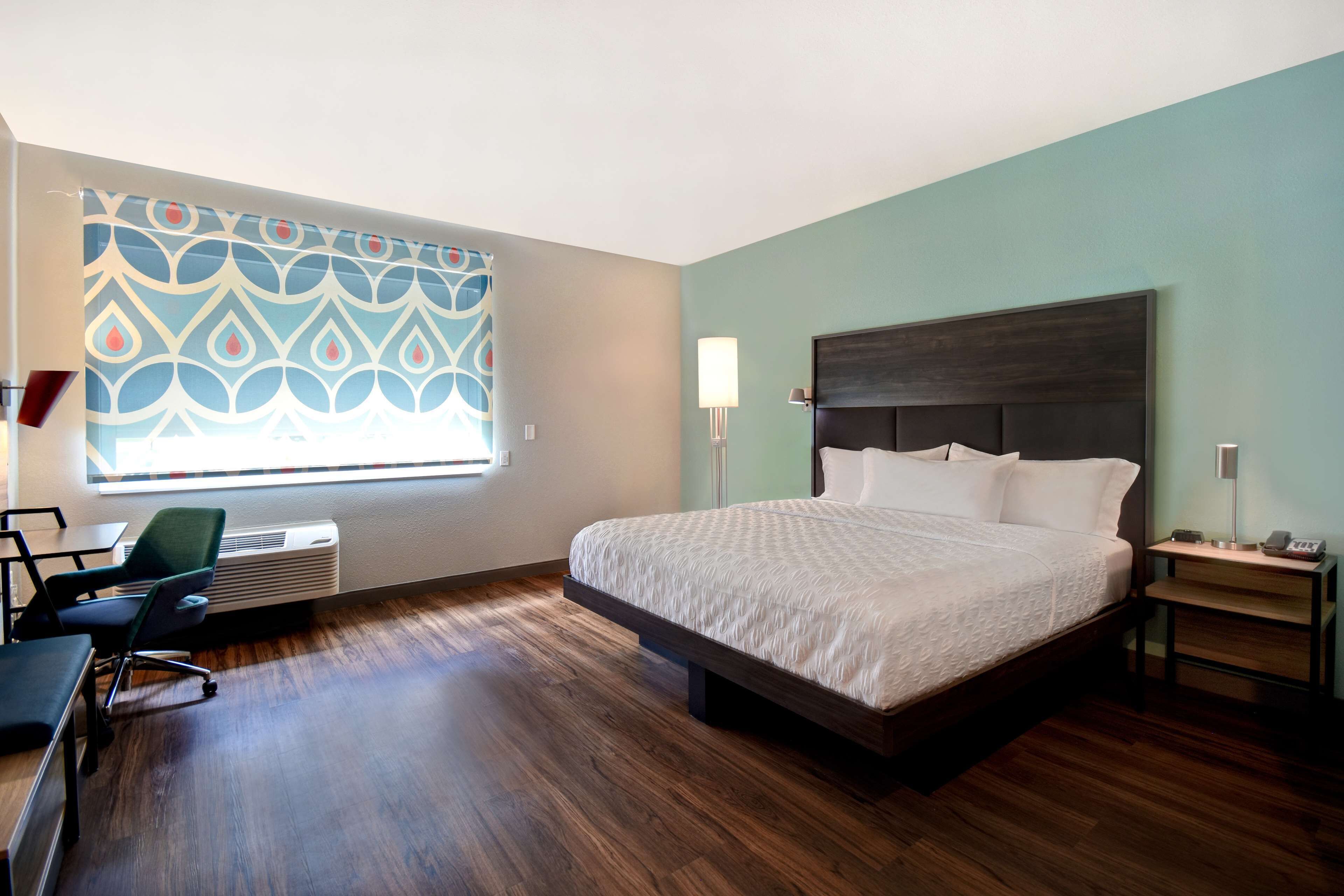 Una habitación de hotel con una cama grande, un escritorio y una silla.