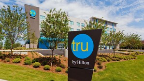 A hotel sign with 'tru by Hilton' branding, surrounded by well-maintained landscaping and a modern building in the background. - Tru By Hilton Prattville (Prattville)