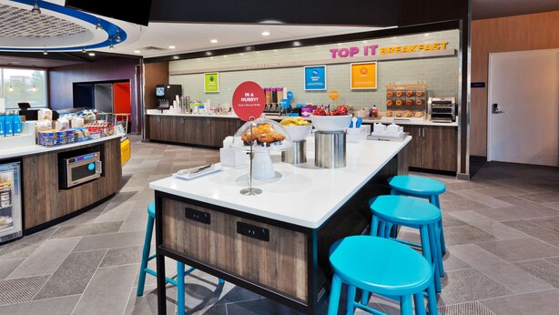 A modern breakfast area with a counter, seating, and a sign reading "TOP IT BREAKFAST". - Tru By Hilton Prattville (Prattville)