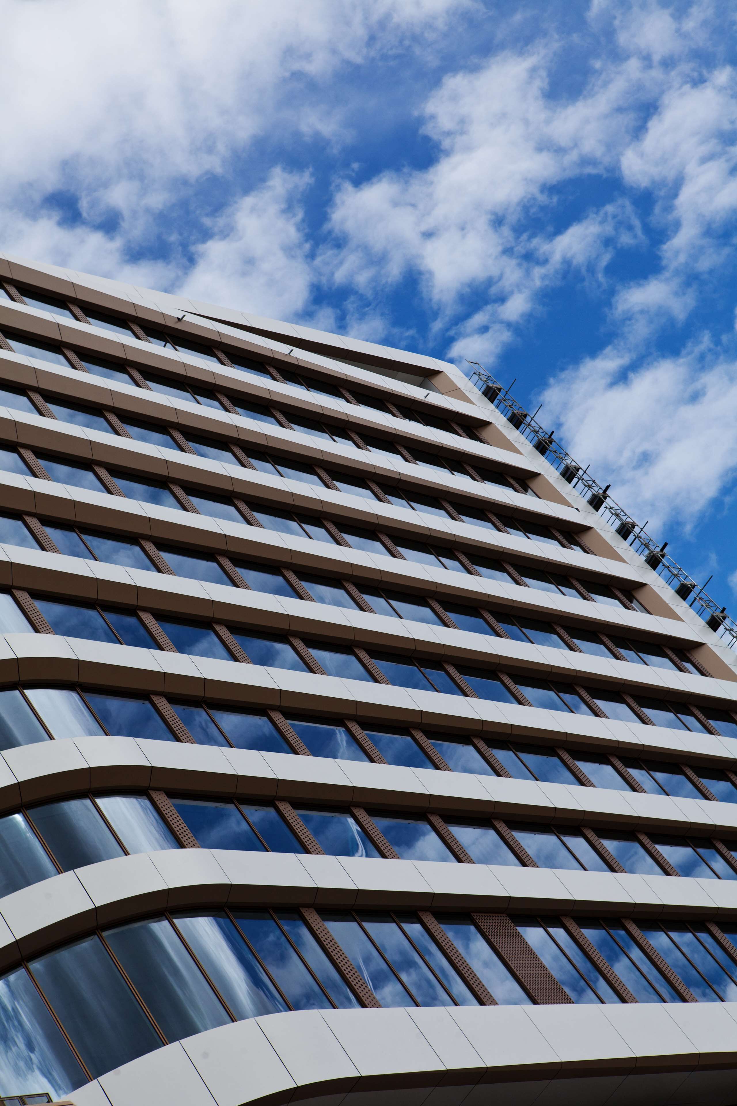 Un edificio moderno con fachada curva y grandes ventanales.