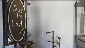 A modern bathroom with a large freestanding bathtub, a mirror with a chalkboard sign, and a minimalist design. - Parion Opus - Adults Only (Paros)