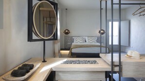 A modern bedroom with a bed, a mirror, a bedside table, and a window. - Parion Opus - Adults Only (Paros)