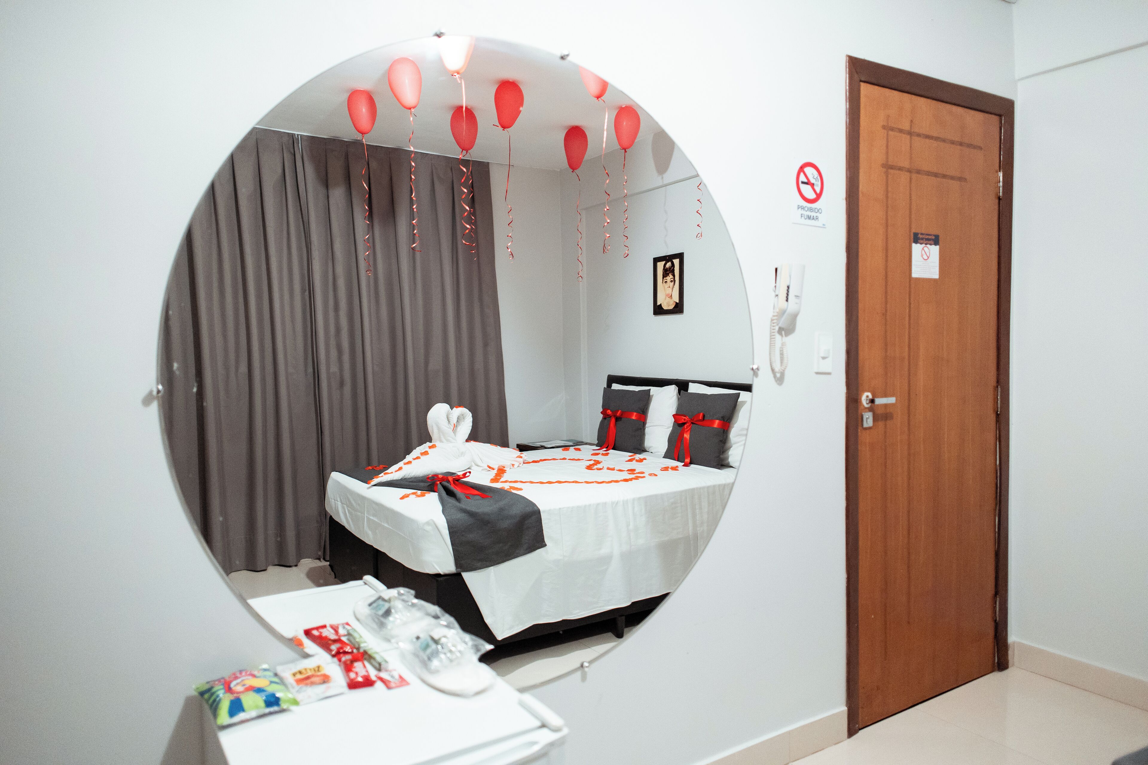 A circular room with a bed, curtains, a door, and a phone.