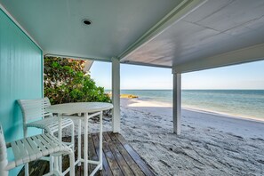 A covered outdoor seating area with a view of a sandy beach and ocean. - Windows on the Water "W.O.W"  An ocean front oasis!   (Captiva)