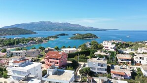 Un pueblo costero con edificios y una vista despejada del mar y las montañas al fondo.