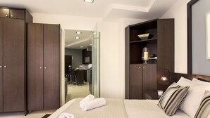 Una habitación de hotel moderna con una cama grande, un escritorio y una kitchenette.