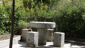 Un banc en pierre, au design simple et robuste, situé dans un jardin.