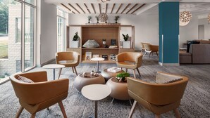 Ein modernes Interieur mit runden Sitzgelegenheiten, einer Holzvertäfelung und einem großen Fenster.