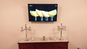 A wooden cabinet with two candelabras and a small decorative item on top. - Pensiunea Rozelor (Simbata de Sus)