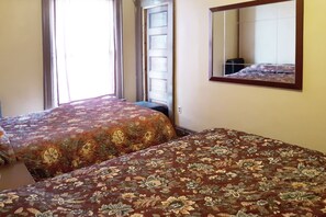 A hotel room with two beds, a large mirror, and a window with curtains. - Hotel Bradford Main St PA (Bradford)
