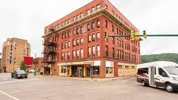 A red brick building with a corner entrance, a fire escape, and a storefront labeled 'OYO HOTEL'.