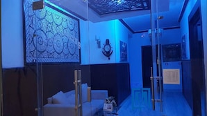 A modern hotel room with a glass partition, a sofa, a small table, and a decorative wall panel. - Montana Connection, Hurghada (Hurghada)