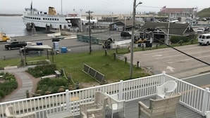 A deck with wicker furniture and a view of the marina.