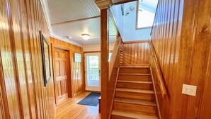 Una scala in legno che conduce a un balcone con vista sul verde.