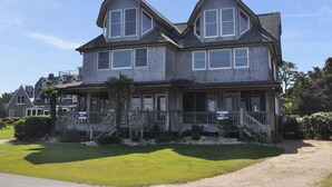 A two-story house with a porch, a front yard, and a driveway.