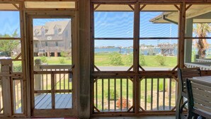 A wooden deck with a view of a residential area and a body of water.