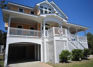 A two-story house with a covered porch, a garage, and a balcony with a lifebuoy decoration.