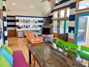 A modern living room with a fireplace, a dining table, and a sofa.