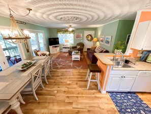 A spacious living area with a kitchen, dining table, and a cozy seating area.