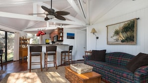 A spacious living area with a large sofa, a coffee table, and a kitchen area with a bar.