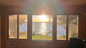 A room with large windows overlooking a body of water and a dock. - Sunset Beach - Log Home on Beautiful Indian Lake (Manistique)