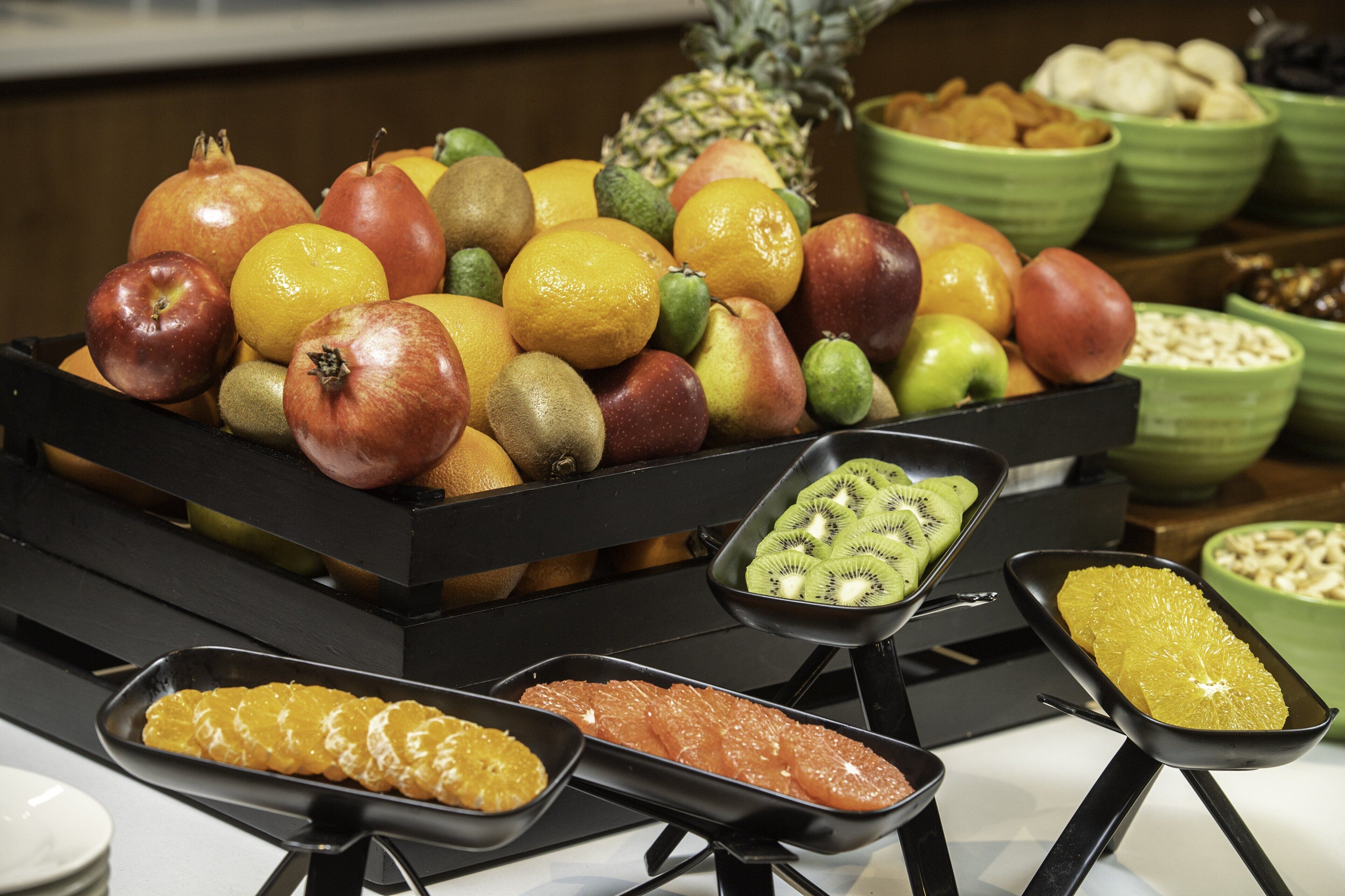 Un buffet proposant une variété de fruits et un assortiment de desserts.
