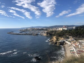 A coastal town with a marina, rocky coastline, and buildings along the shore. - Wonderful apartment in front of the sea (Palamós)