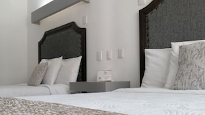 Een moderne hotelkamer met een groot bed, een nachtkastje en een hoofdbord met een structuur.