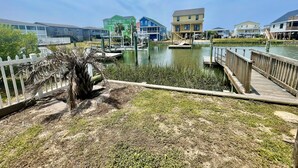 Um imóvel à beira-mar com um cais, um pequeno lago e casas coloridas ao fundo.