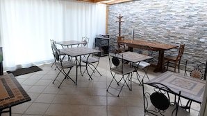 A dining area with a stone wall, wooden ceiling, and tiled floor. - Sicily Bike (Serradifalco)