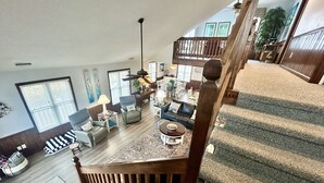 Ein geräumiger Wohnbereich mit einer Holztreppe, die in eine obere Etage führt.