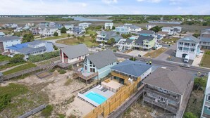 A coastal residential area with houses, a swimming pool, and a beach. - Newly Renovated, 4 bed 2 bath, Pet Friendly Oceanfront w/ a Pool! (Brunswick)