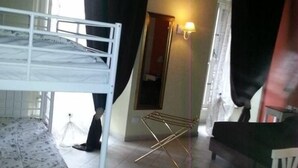 A dormitory room with bunk beds, a drying rack, a mirror, and a small seating area. - Chocolat Inn (Rome)