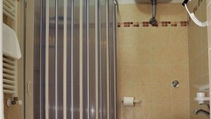 Un baño con cabina de ducha, inodoro, bidé y lavamanos.