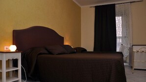 A bedroom with a bed, bedside table, and a nightstand. - Chocolat Inn (Rome)