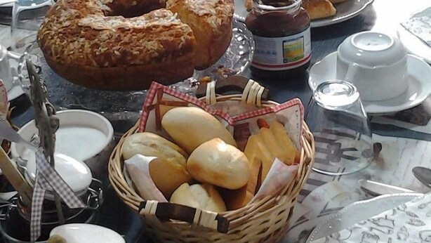 A breakfast table with various pastries, bread, and a jug of orange juice. - Chocolat Inn (Rome)
