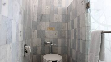 Un baño con inodoro, toallero y cabina de ducha de vidrio.