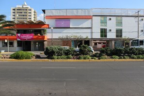 A hotel with a flat roof, a balcony, and a sign for the Flamingo Hotel.