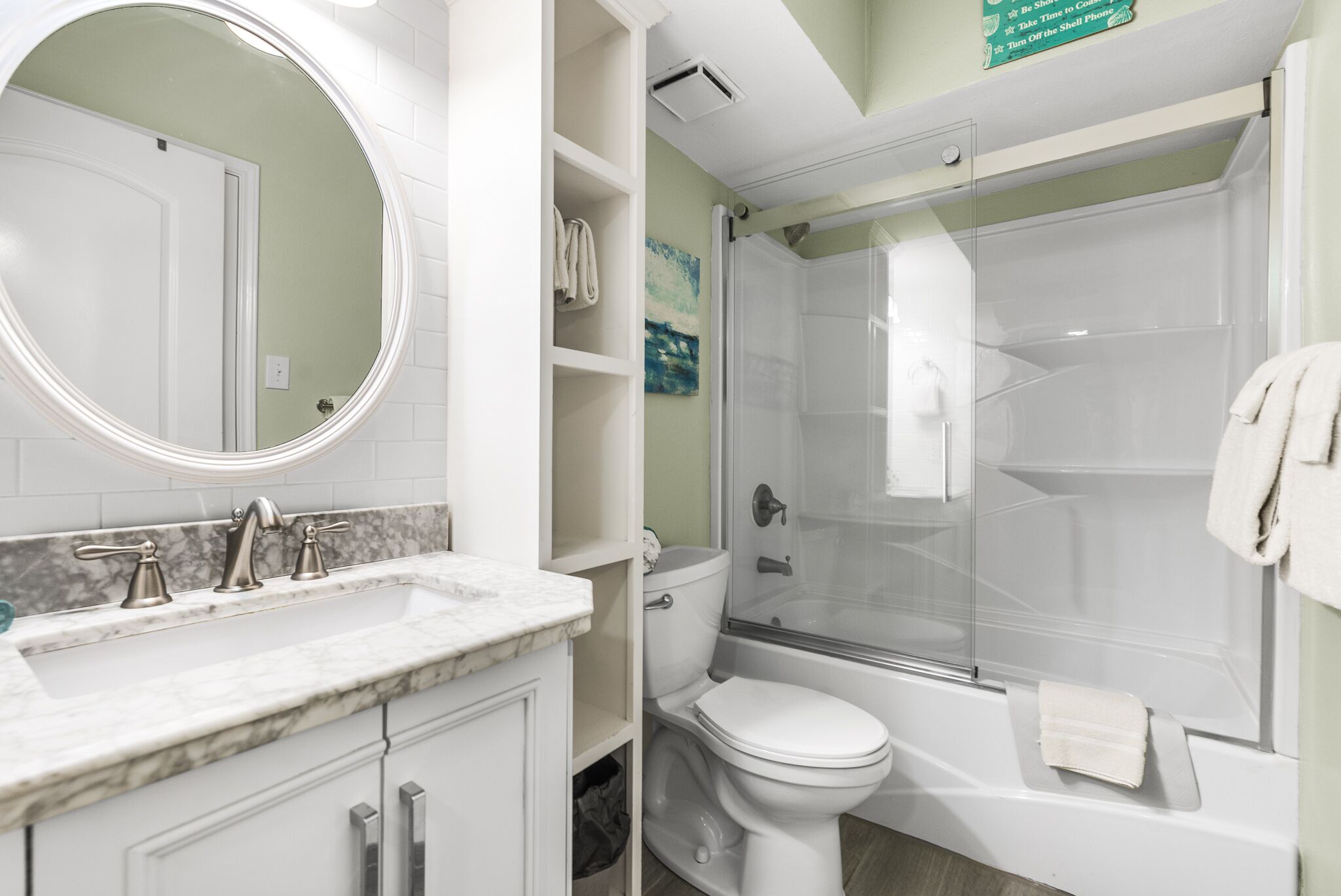 A bathroom with a white sink, a toilet, and a glass-enclosed shower.
