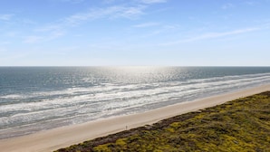 A beach with a clear sky and ocean waves. - Sandpiper Condominiums 1208, Panoramic Gulf Views w/ direct access to Mustang Island/Port A beaches. (Port Aransas)