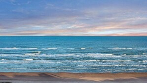 Ein Strand mit Wellen und blauem Himmel.