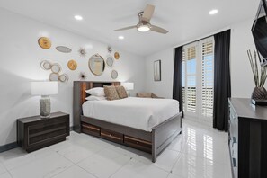 Un dormitorio moderno con cama, mesitas de noche, ventilador de techo y decoración mural.