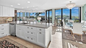 A spacious kitchen with a large island, modern appliances, and a view of the outdoors.