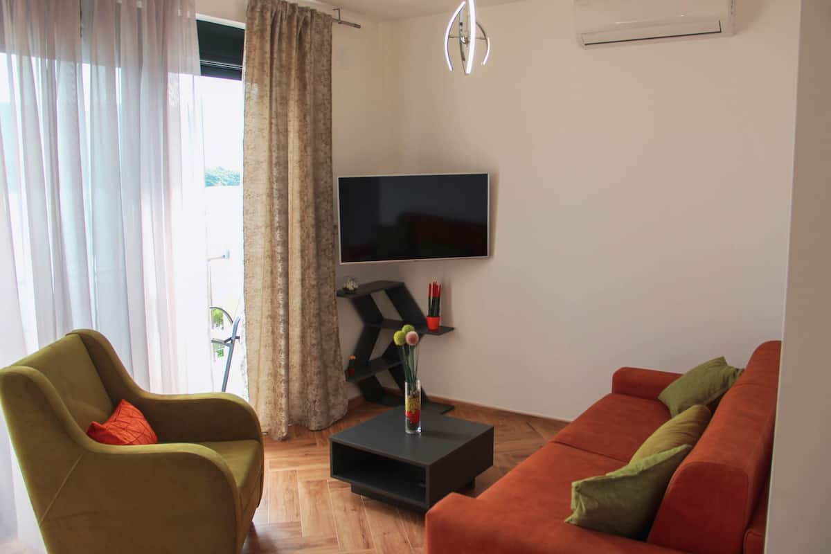Elite appartement | Woonkamer | Een 39-inch flatscreentelevisie met kabelzenders en een televisie