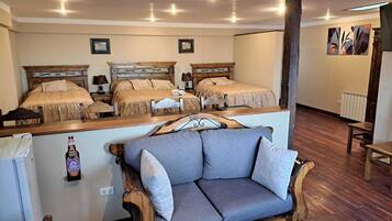 Habitación de hotel con dos camas, un sofá y un mini bar.