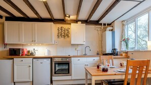 A kitchen with white cabinets, a microwave, a toaster, and a sink. - Orchard Cottage - UK30437 (Langport, near Somerton)