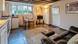 A kitchen with a dining table, chairs, a TV, and a sofa. - Orchard Cottage - UK30437 (Langport, near Somerton)