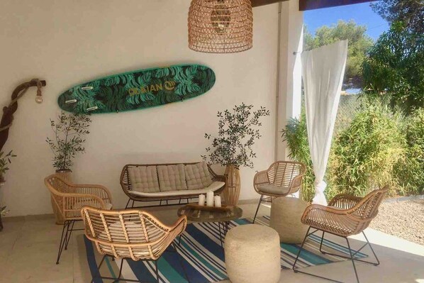 A cozy outdoor seating area with wicker furniture, a skateboard, and decorative plants.