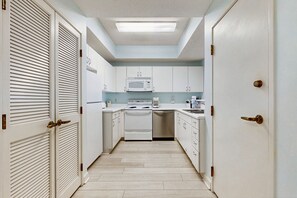 Enjoy cooking in this well-equipped kitchen with a central island, appliances, and a skylight above.